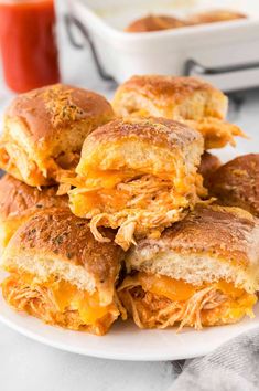 a white plate topped with cheesy sandwiches next to a bowl of ketchup