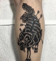 a black and white tattoo on the leg of a person with an animal design on it