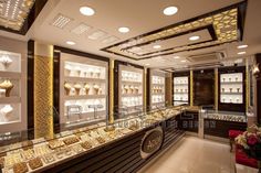 the interior of a jewelry store with gold and white items on display in glass cases