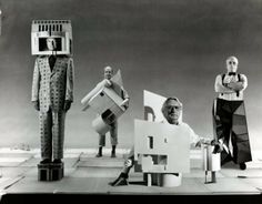 an old black and white photo of three men standing in front of some cardboard figures