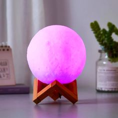 a pink light sitting on top of a wooden stand