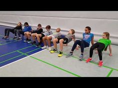 a group of kids sitting on top of a blue and green floor next to each other