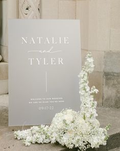 a sign that says natalie and tyler is next to some flowers on the steps outside