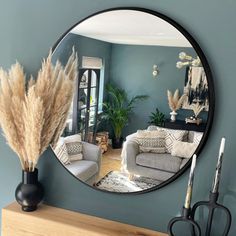 a living room filled with furniture and a round mirror