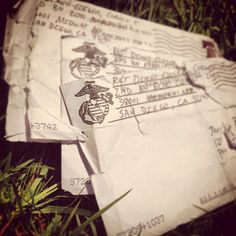 two envelopes are laying in the grass with us marine seal stamps on them,