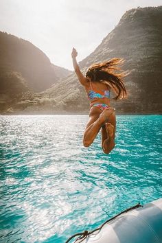 a woman jumping into the water from a boat