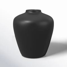 a black vase sitting on top of a white table