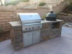 an outdoor bbq grill is built into the side of a brick wall and has a green dome on top