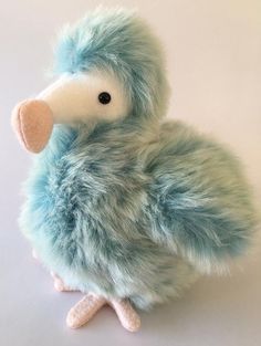 a stuffed animal that looks like a bird with feathers on it's head and legs