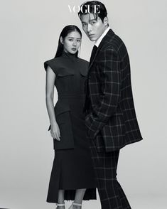 a man and woman standing next to each other in front of a white background with the word vogue written on it