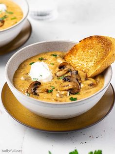 two bowls of soup with bread and sour cream