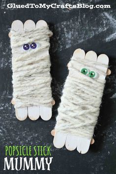 two gloves made out of yarn with eyes on them and the words popsicle stick mummy