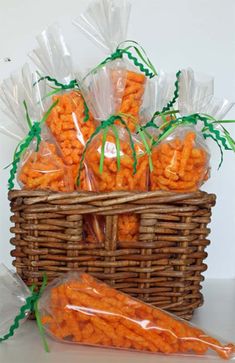 a basket filled with carrots sitting on top of a table next to bags of carrots