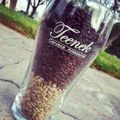 a glass filled with seeds sitting on top of a sidewalk