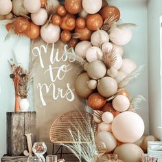 a table topped with lots of balloons next to a sign that reads miss to mrs