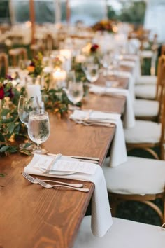 a long table is set with place settings and wine glasses