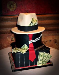 a cake made to look like a hat and tie with money coming out of it