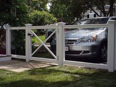 a car is parked in front of a white fence