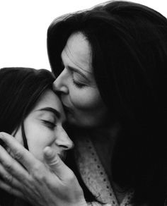 two women are kissing each other in black and white