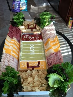 a football field made out of chips and lettuce is displayed on a table