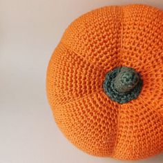 an orange knitted pumpkin sitting on top of a white table