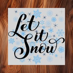 the words let it snow written in black ink on a white paper surrounded by snowflakes