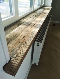 the window sill is made out of wood and has a heater on it