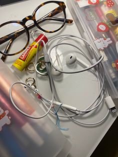 a pair of glasses, headphones and other items on a table