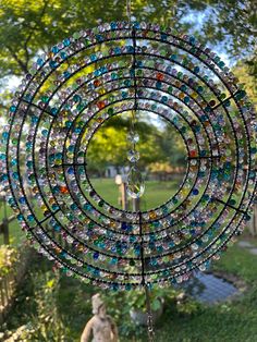 a wind chime hanging from the side of a tree in a yard with grass and trees