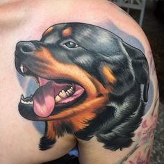 a close up of a person with a dog tattoo on their back shoulder and chest