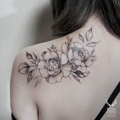 the back of a woman's shoulder with flowers and leaves on her left shoulder