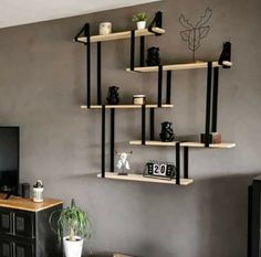 a living room filled with furniture and a flat screen tv on top of a wooden shelf