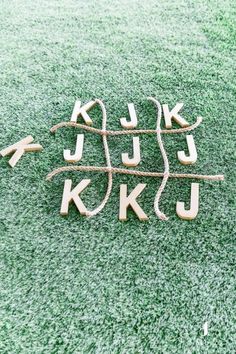 the letters are made out of wood and rope on the ground with grass in the background