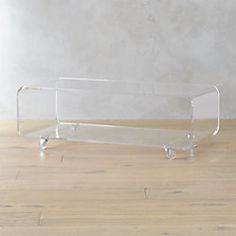 a clear glass shelf sitting on top of a wooden floor