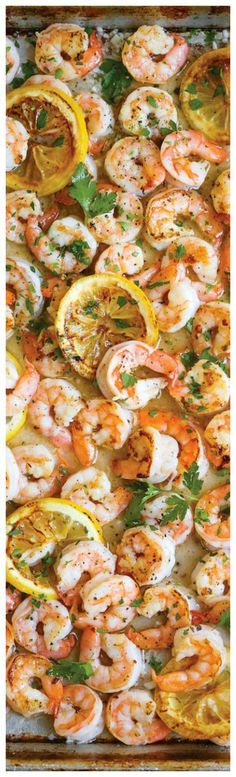 a pan filled with shrimp and lemon slices