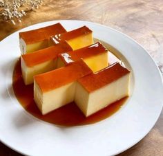 four pieces of cheesecake on a plate covered in caramel sauce and flavy