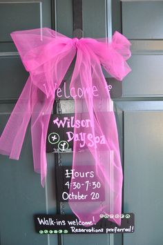 a welcome sign hanging on the front door of a house with pink tulle bow