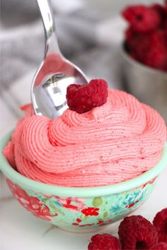 raspberry frosting in a bowl with a spoon sticking out of the top