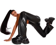 a woman in black leather pants and high heels posing for the camera with her legs spread out