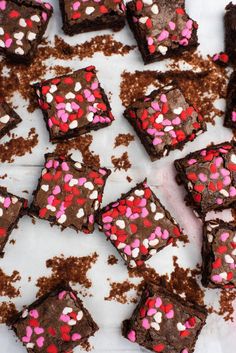 chocolate brownies with pink and white sprinkles on top are arranged in rows