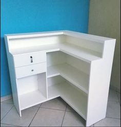 an empty white corner cabinet in the corner of a room with blue walls and tile flooring