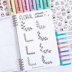 a notebook with several different colored markers next to it