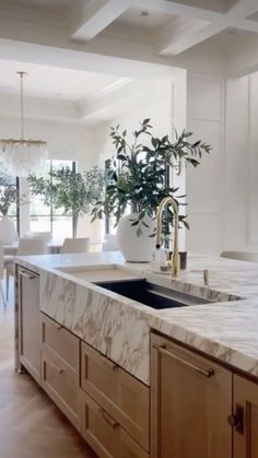 a large kitchen with marble counter tops and wooden cabinetry, along with an island