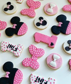 minnie mouse cookies are arranged on a white table with pink and black polka dot decorations