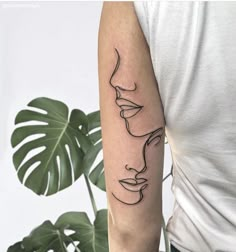 a woman's arm with a line drawing of her face on the left forearm