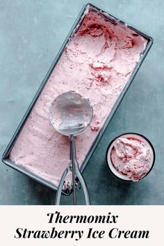 thermomix strawberry ice cream is in a metal container next to a spoon