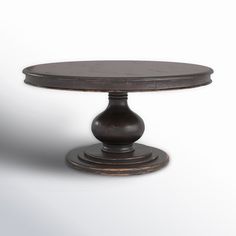 a round wooden table sitting on top of a white floor