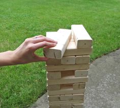 a hand holding onto a block of wood