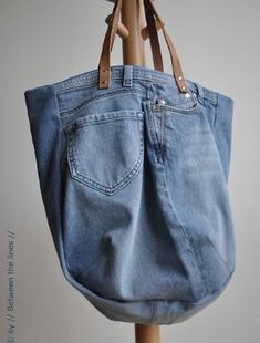 a denim bag hanging on a wooden rack