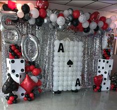 a casino themed party with balloons, dices and streamers on the wall in front of it